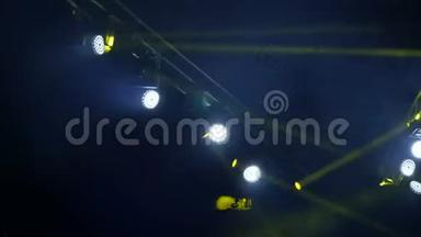 舞台上的蓝色和黄色灯光。 肥皂剧在音乐会上闪闪发光。 发光的舞台灯光在烟雾中闪烁